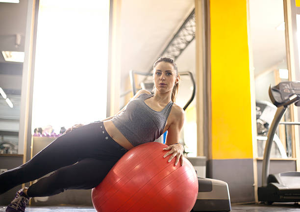 istock Young woman lying back on exercise ball in gym 509543856