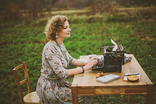 istock Woman prints on old vintage typewriter 509547414