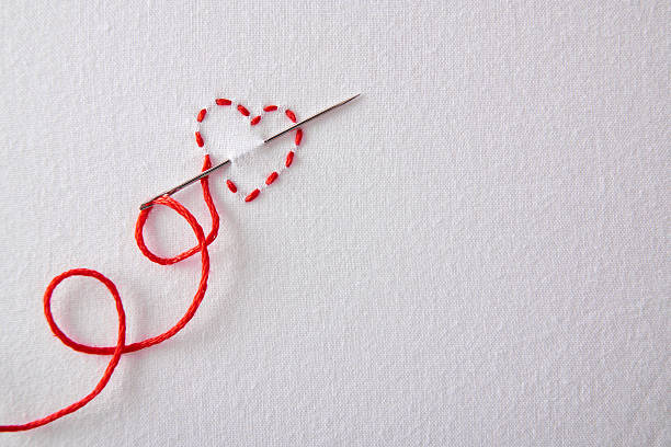 bordado de coração vermelho sobre um pano branco vista superior - thread tailor art sewing imagens e fotografias de stock