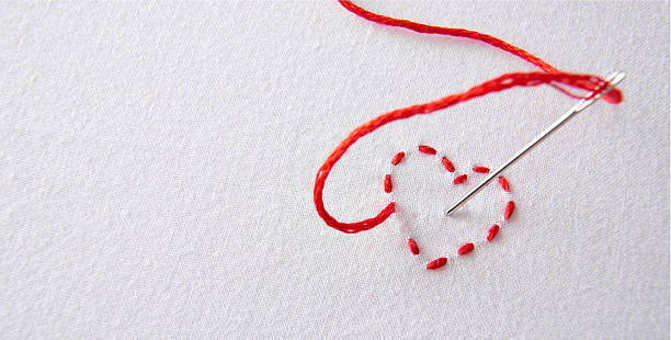 rouge cœur brodé sur un tissu blanc avec aiguilles troués par exemple - sewing tailor thread sewing kit photos et images de collection