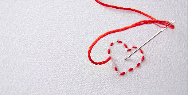 istock Embroidered red heart on a white cloth with needle punctured 509551968
