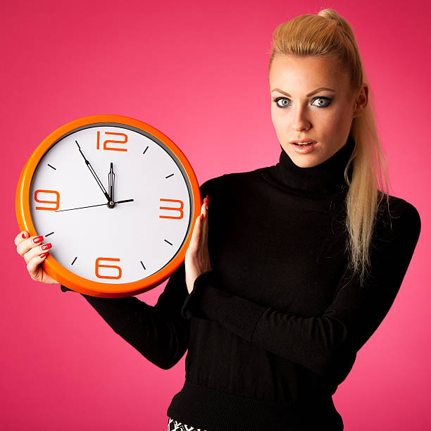 istock Worried woman with big orange clock gesturing delay, rush, stress 509552070