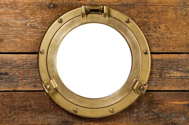 old brass porthole in wooden wall, window isolated with clipping path