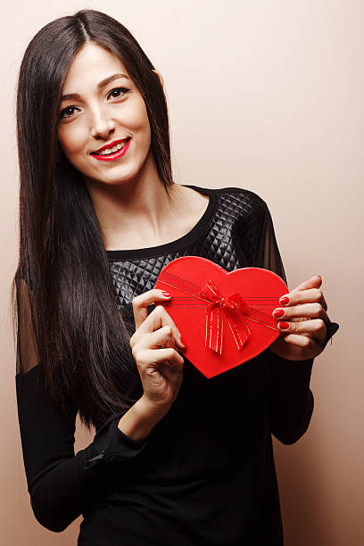 istock Beautiful young girl with heart gift box 509552592