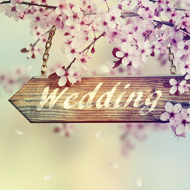 Wedding sign on wooden plank  in front on spring garden
