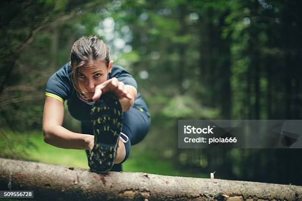 Woman Athlete Stretching In The Forest After Running Stock Photo - Download Image Now