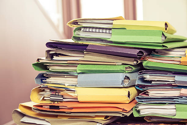 bureau désordonné de nombreux dossiers de documents en couleur - book stack old heap photos et images de collection