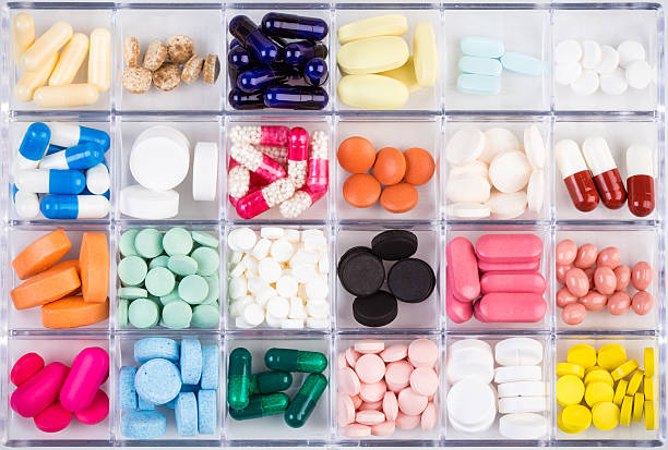 Various pills and capsules in container stock photo