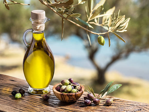 azeite de oliveira e bagas estão na mesa de madeira. - azeite imagens e fotografias de stock