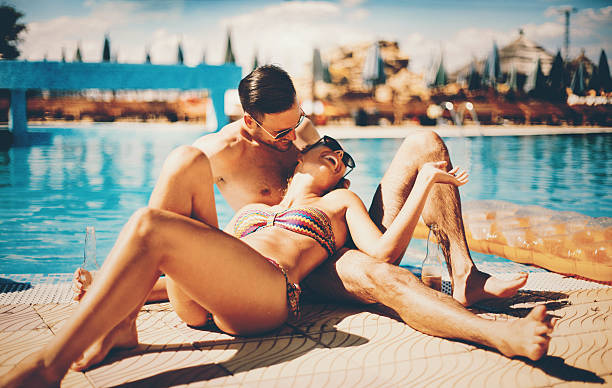 par relajante junto a la piscina. - honeymoon beach swimming pool couple fotografías e imágenes de stock