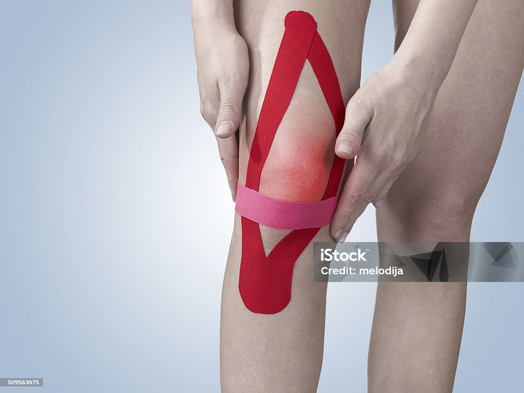 Acute pain in a woman knee. Acute pain in a knee. Woman holding hand to spot of knee-aches. Adult Stock Photo