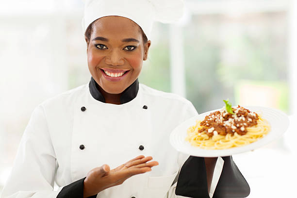 istock african female chef holding spaghetti dish 509565845