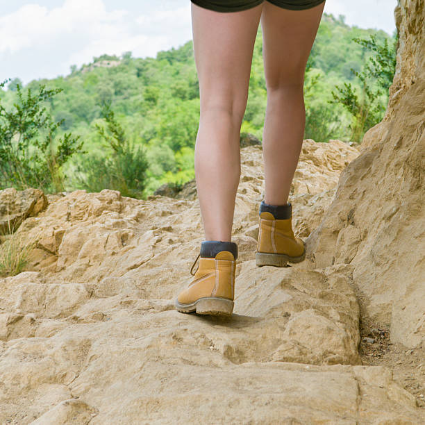 Female hiker walking along and over the rocks