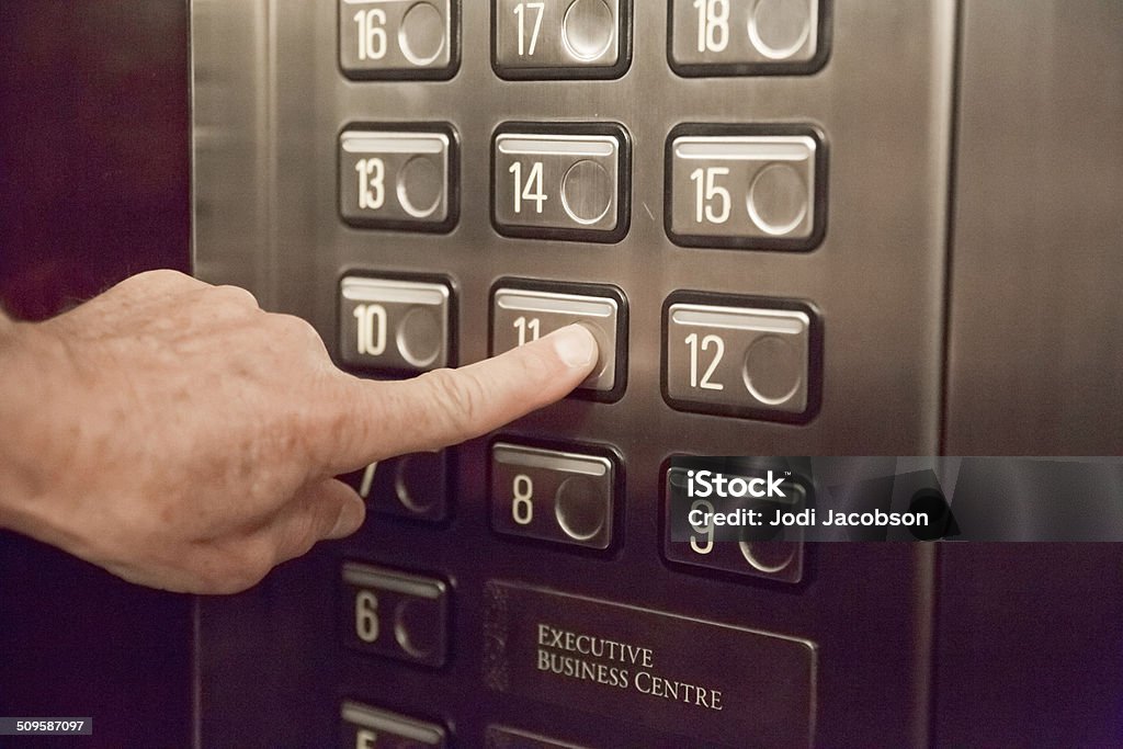 Pushing elevator buttons Man pushes an elevator button for his floor.  rm Elevator Stock Photo