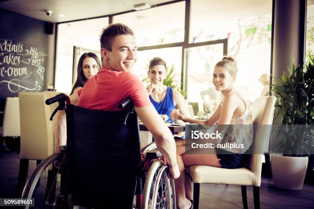 Young Disabled Man Having Fun With His Friends At Cafe Stock Photo - Download Image Now