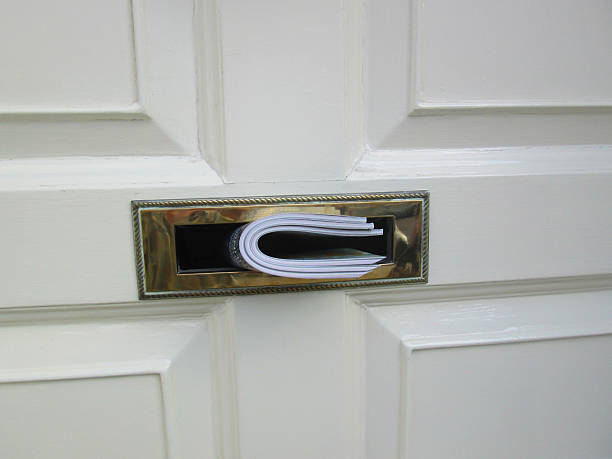 istock White front door, wooden panels, magazines pushed through brass letterbox 509589861