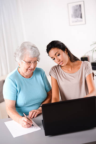 istock young woman helping elderly person with computer internet search email 509609017