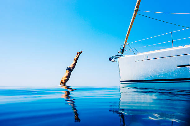 uomo saltare in mare con barca a vela - cruise ship cruise mediterranean sea sea foto e immagini stock