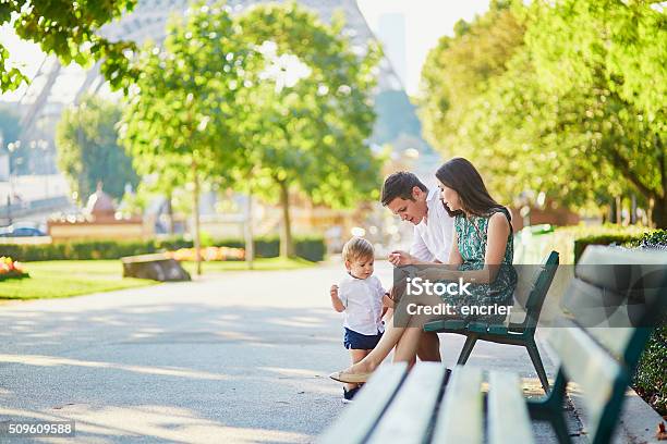 Happy Family Of Three Sitting Near The Eiffel Tower Stock Photo - Download Image Now
