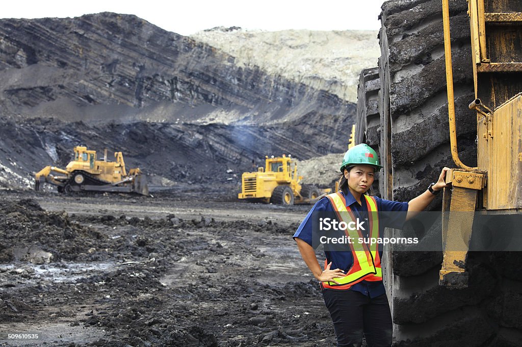 Serious Female Construction Woker A royalty free image from the construction industry of a serious female construction worker in front of a dump truck at a construction site. Mining - Natural Resources Stock Photo
