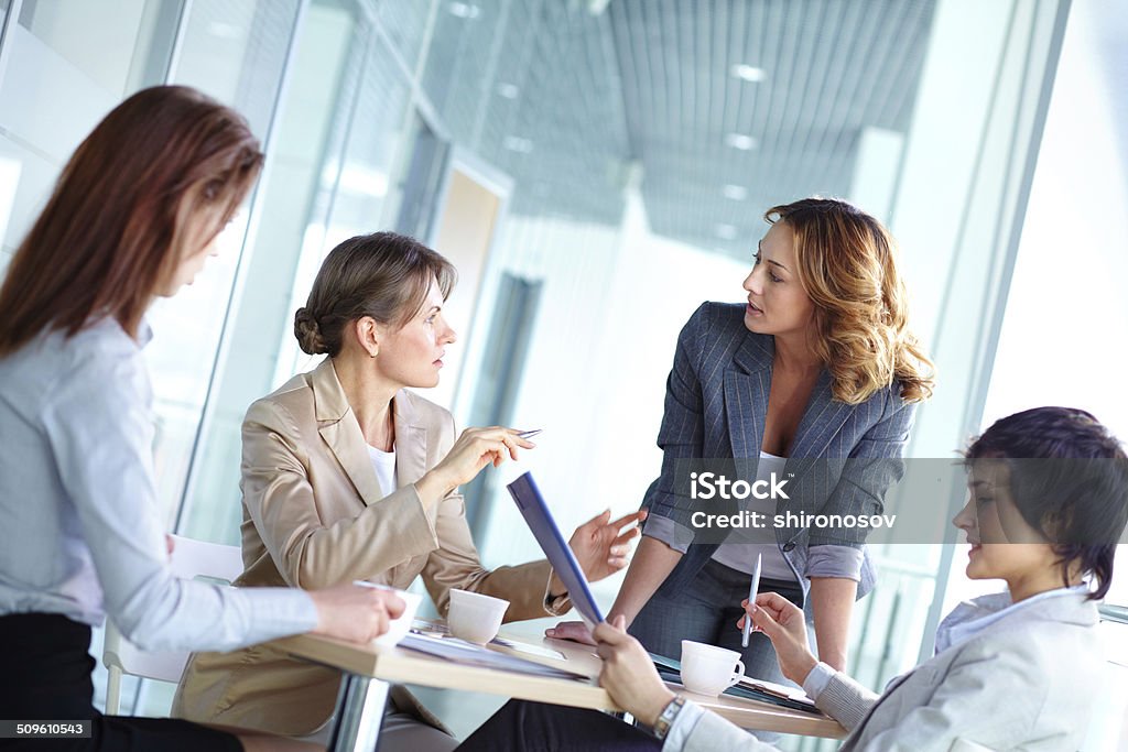 Female brainstorming Lovely business ladies gathered for a brainstorm Women Stock Photo