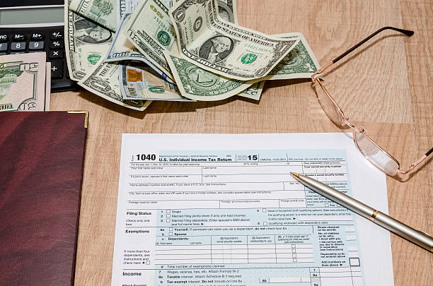 istock federal income tax return 1040 documents with pen, calculator, dollars 509611614