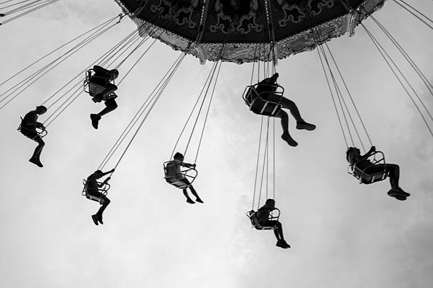 sunset of several swings giving a shadow of a person riding on them