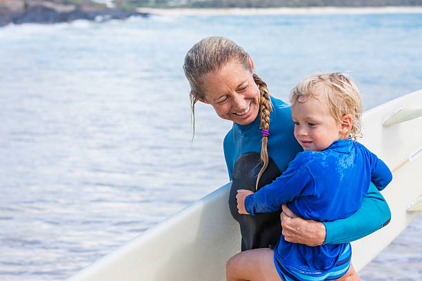 istock Mother Taking Her Young Child Surfing at the Beach 509611730