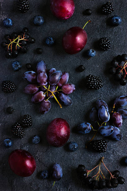 istock fresh dark fruits and berries on black background. 509612026