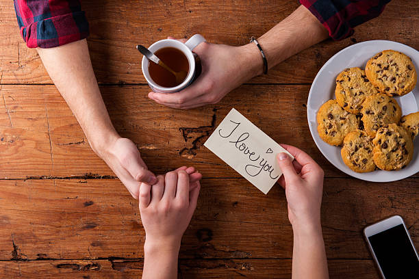 Unrecognizable mans and womans hands. Romantic message. Tea and