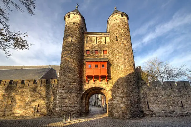 Historical city gate Helpoort with parts of the old city wall in the evening sunlight in Maastricht, Holland