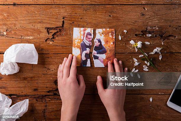 Unrecognizable Sad Woman Holding Torn Picture Of Couple In Love Stock Photo - Download Image Now