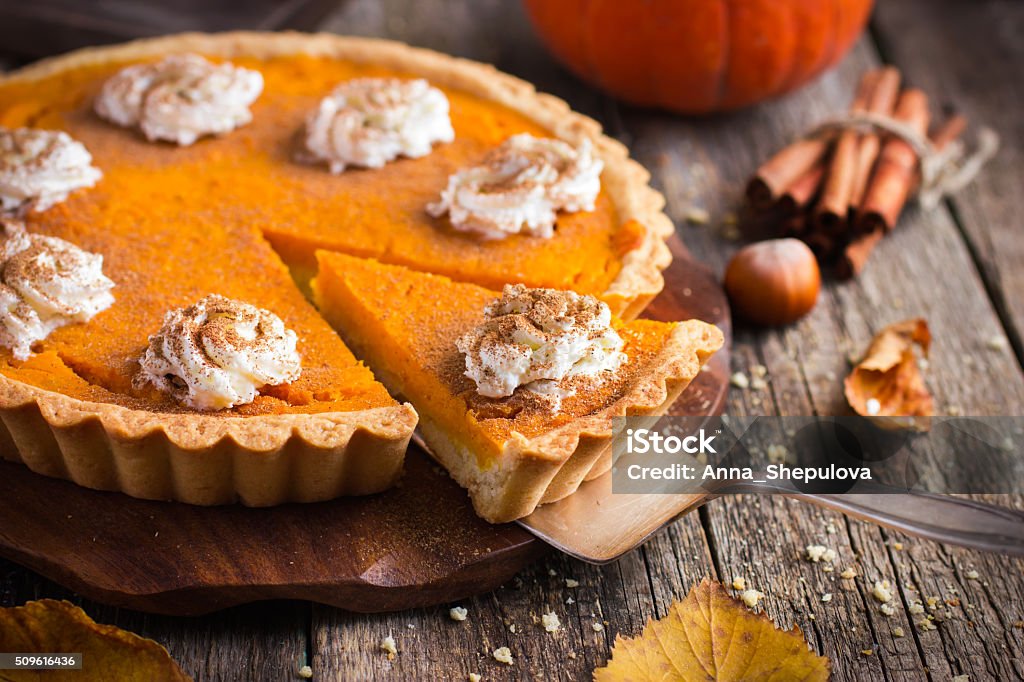 pumpkin pie with whipped cream and cinnamon pumpkin pie with whipped cream and cinnamon on rustic background, top view Pumpkin Pie Stock Photo