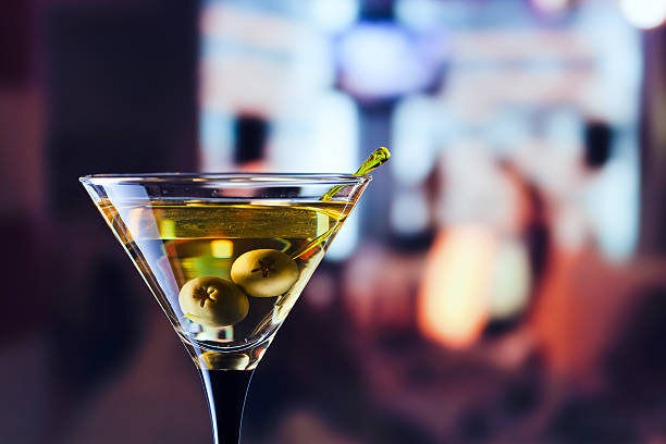 glass with martini and green olives glass with martini , focus on a olives martini photos stock pictures, royalty-free photos & images