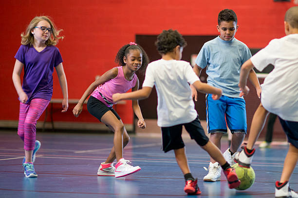 un groupe de multi-ethnique d'âge élémentaire des enfants - soccer child indoors little boys photos et images de collection