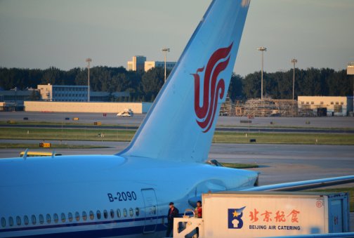 Beijing, China - September 11, 2012: ground crew workers arrive to deliver catering to an Air China Boeing 777 at Beijing Capital International Airport