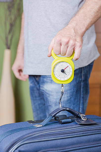 istock Man checking luggage weight with steelyard balance 509625771