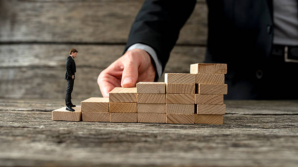 istock Businessman building a staircase for another entrepreneur to cli 509625970