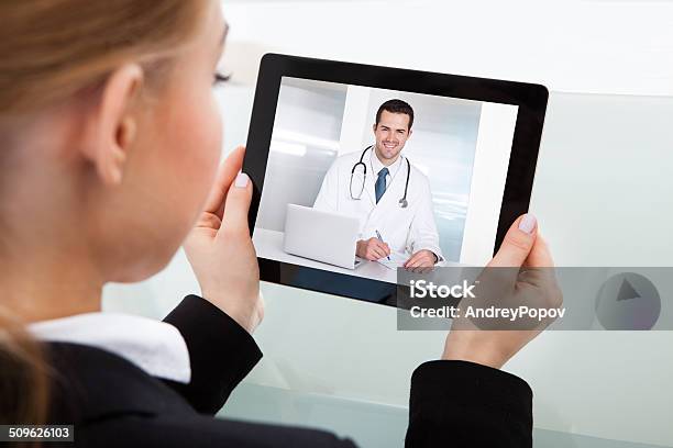 Businesswoman Having Video Chat Stock Photo - Download Image Now - Doctor, Video Conference, Watching