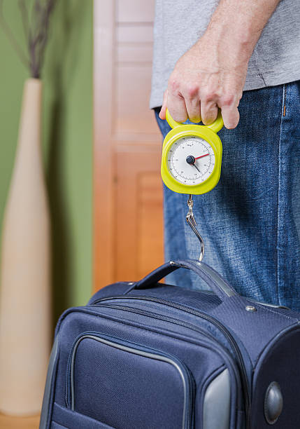 istock Man checking luggage weight with steelyard balance 509626269