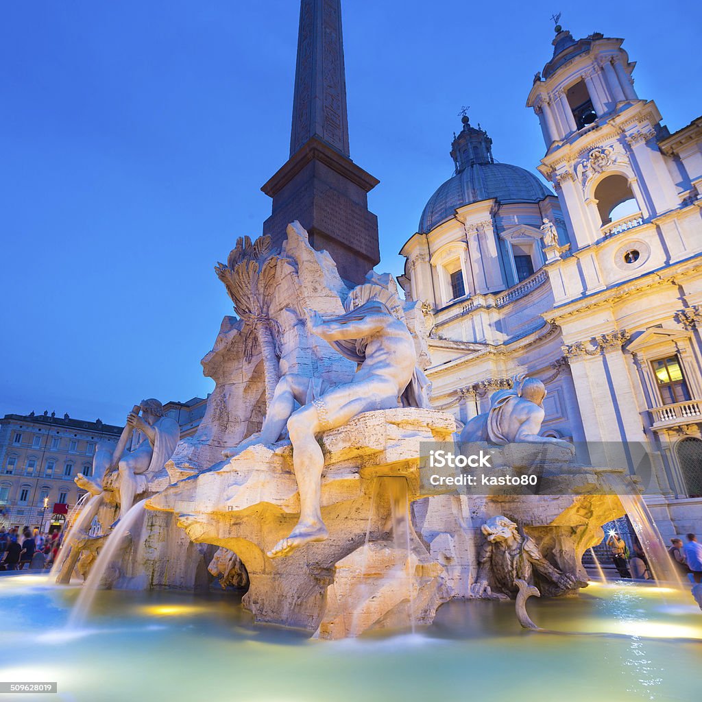 Navona square in Rome, Italy. Fountain of the four Rivers and SantAgnese in Agone on Navona square in Rome, Italy, Europe shot at dusk. Ancient Stock Photo