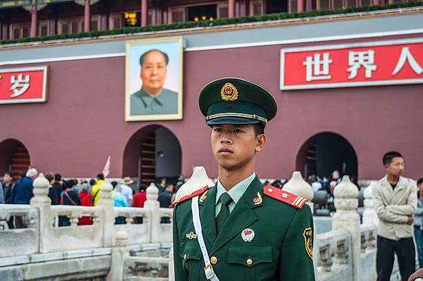 China Soldier at Tien'anmen Square stands duty at the entrance Beijing, China - October 13, 2013: A Chinese soldier stands guard in front of the Gate of Heavenly Peace between Tiananmen Square and The Forbidden City in Beijing, China. Behind the soldier is a large portrait of Chairman Mao Zedong, leader of the Communist Party of China. communism photos stock pictures, royalty-free photos & images