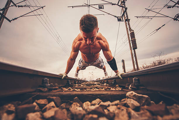 柔軟体操に鉄道のトラック。 - low angle view macho men urban scene ストックフォトと画像