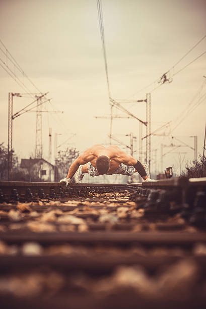 отжимания на железнодорожный. - low angle view macho men urban scene стоковые фото и изображения