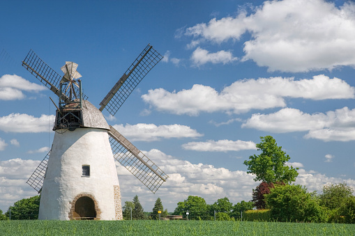 Old restored windmill countryside with blue sky and white clouds. 
