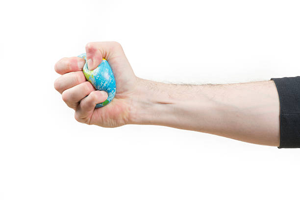 борьба с нищетой во всем мире - crushed human hand earth ball стоковые фото и изображения