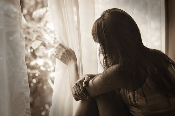 istock Sad girl looking out of window 509632956