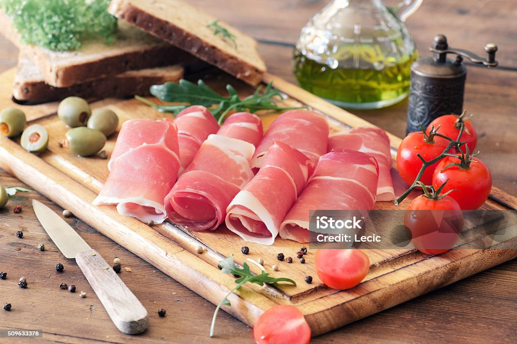 sliced prosciutto on a wooden board Prosciutto Stock Photo