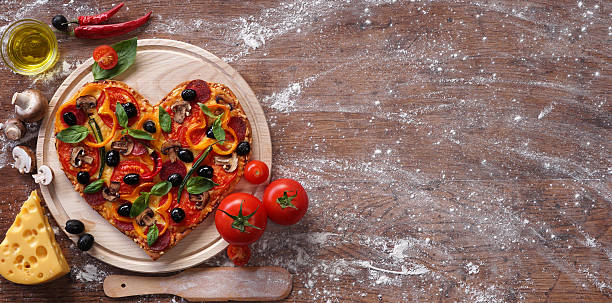 istock Pizza heart shape with ingredients and copy space 509633434