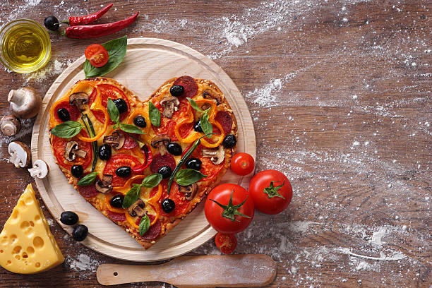 istock Tasty heart shaped pizza decorated with vegetables 509633540